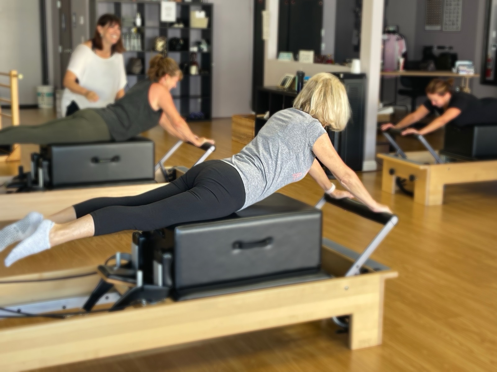 A client extending into a swan stretch on the reformer